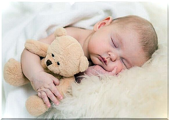 sleeping infant with teddy bear