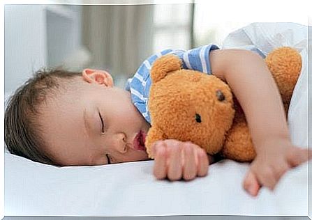 Boy sleeping in his own bed with teddy bear