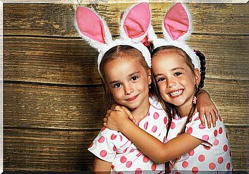 Identical twins with polka dot sweater and rabbit ears.