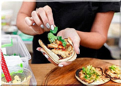 woman puts coriander on wrap