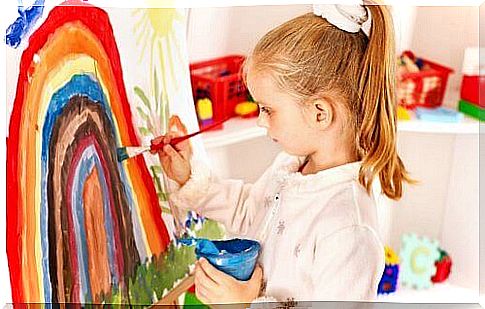 A child painting a rainbow.