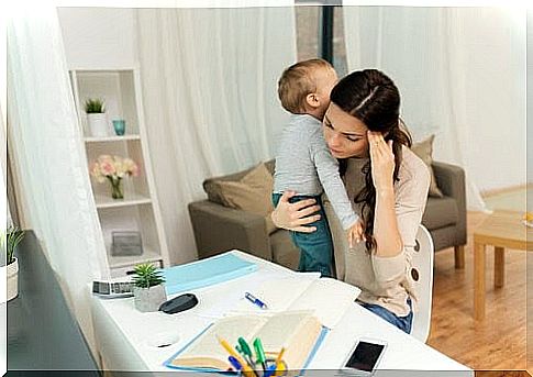 Woman trying to study with small child on her arm