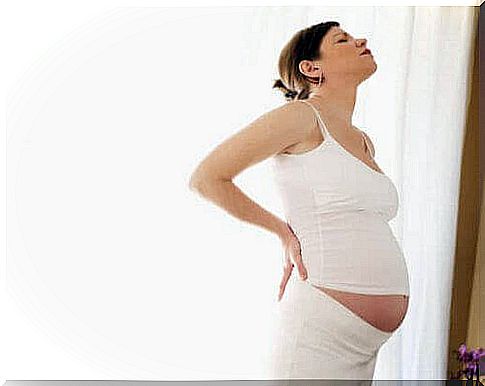 easy and complicated deliveries: pregnant woman holds her back