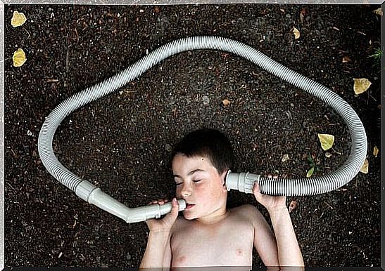 Boy lying on the ground with hose