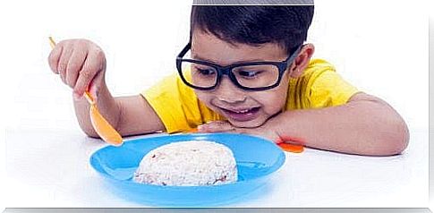 boy looking at a plate of rice