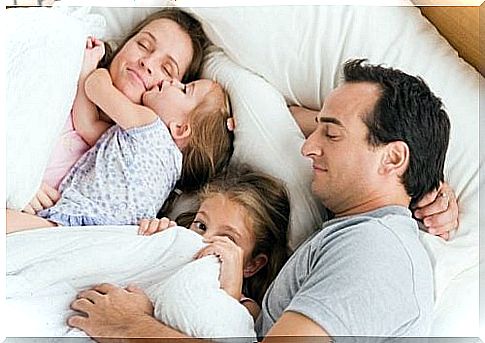 A family resting together in bed.