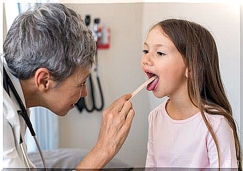 doctor examines tongue on girl