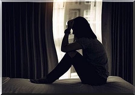 depression affects the relationship: woman sitting on the floor in dark room