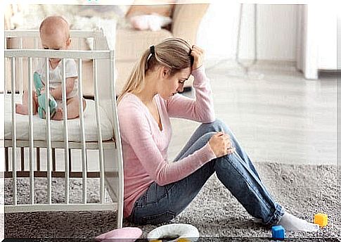 depression affects the relationship: woman sitting on the floor next to crib