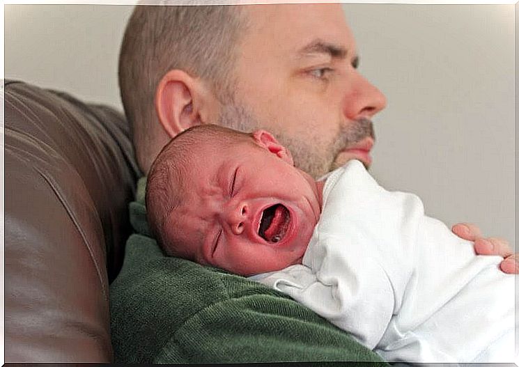 dad comforts screaming baby