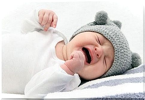 Baby with gray hat crying