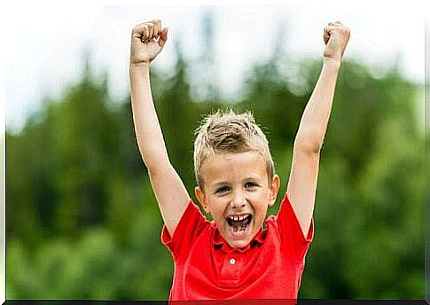 positive self-esteem: boy makes gesture of victory