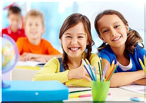 Siblings smiling at desk