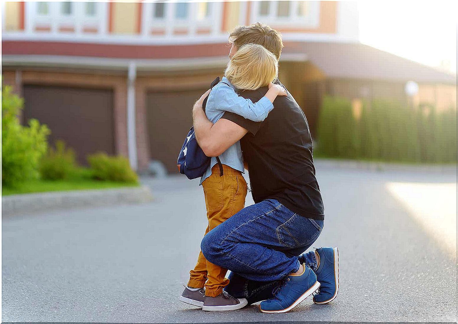 A boy hugs his father on the way to school.