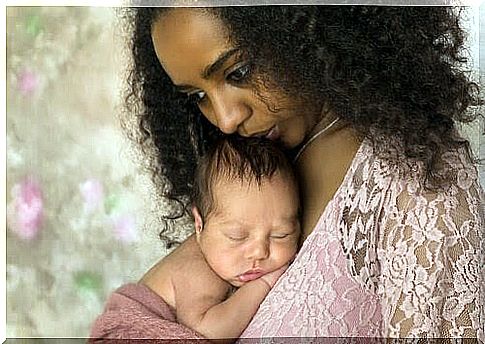 Mom holds babies, looks depressed