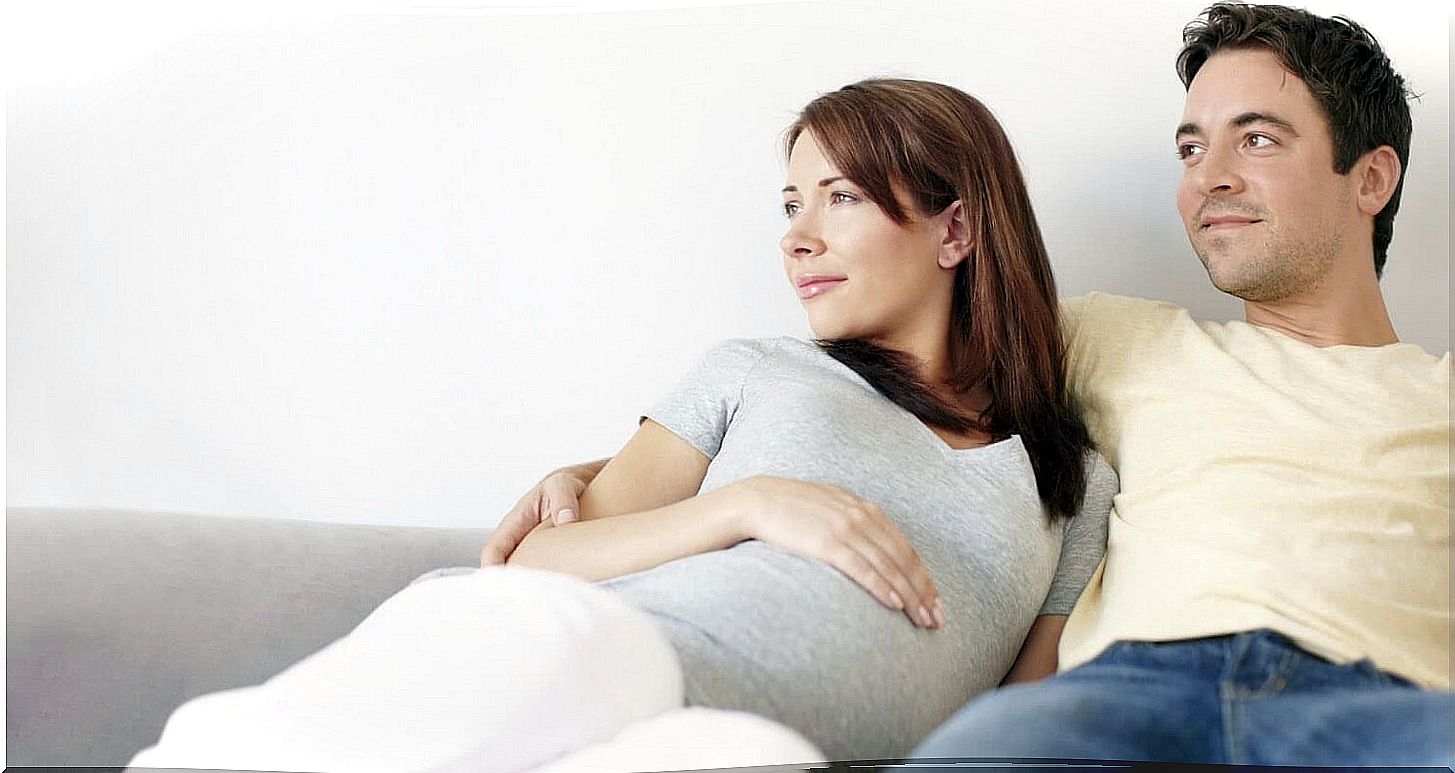 man and pregnant woman on sofa