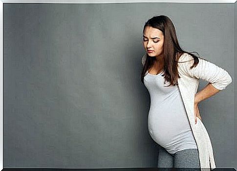 Pregnant woman holding her back