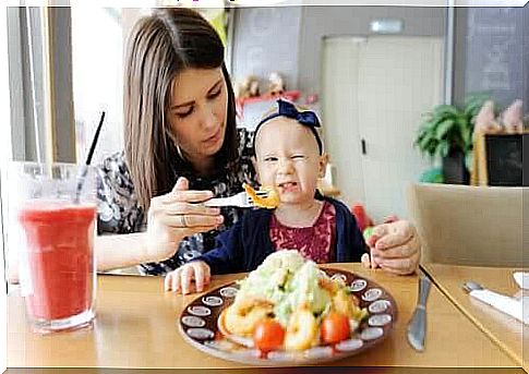 children to eat well: baby grimaces when mother tries to feed her