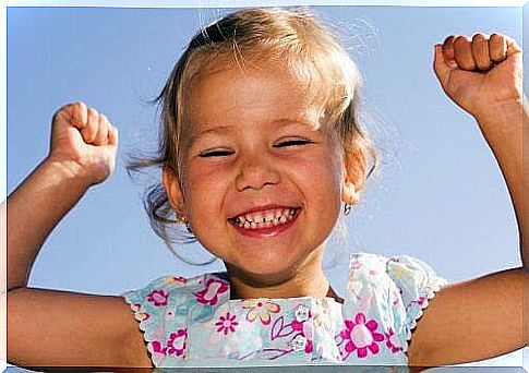 Optimistic children: happy girl makes victory gesture