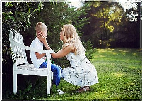 Mother comforts son on bench