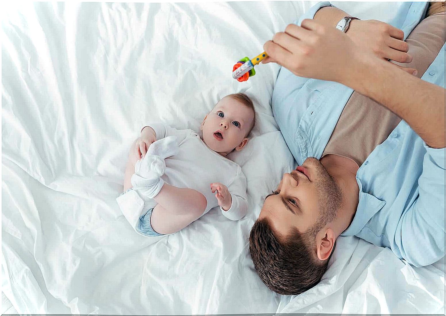 emotional bands and musical instruments: dad shows rattle to baby