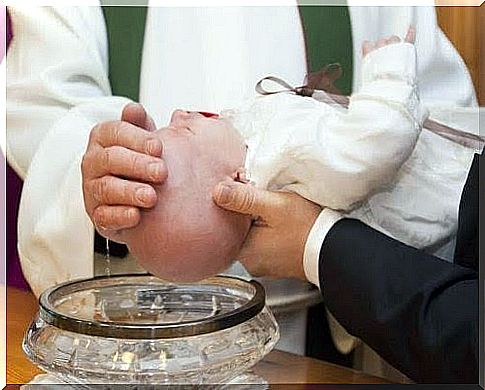 God-parent holds out babies who are baptized by a priest