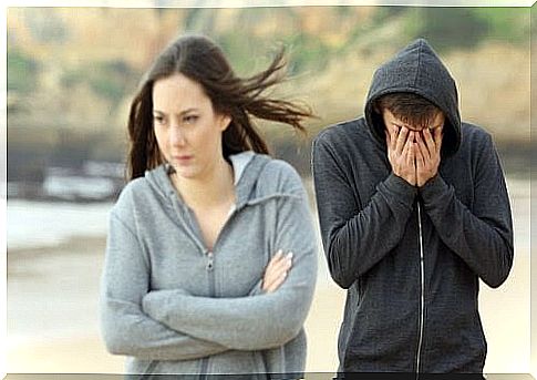 young couple on beach, looking to be enemies