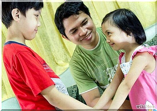 father and two children, smiling at each other