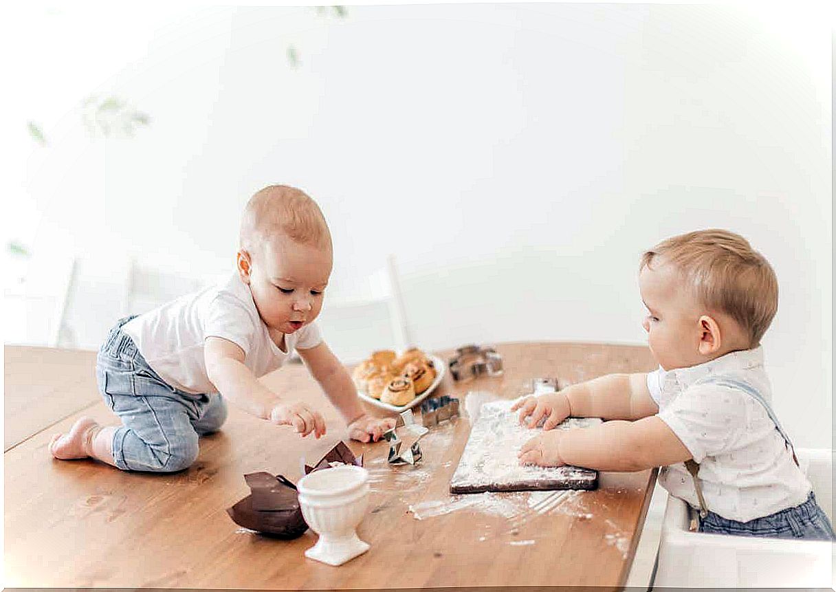 Two children are playing with flour and pastries.